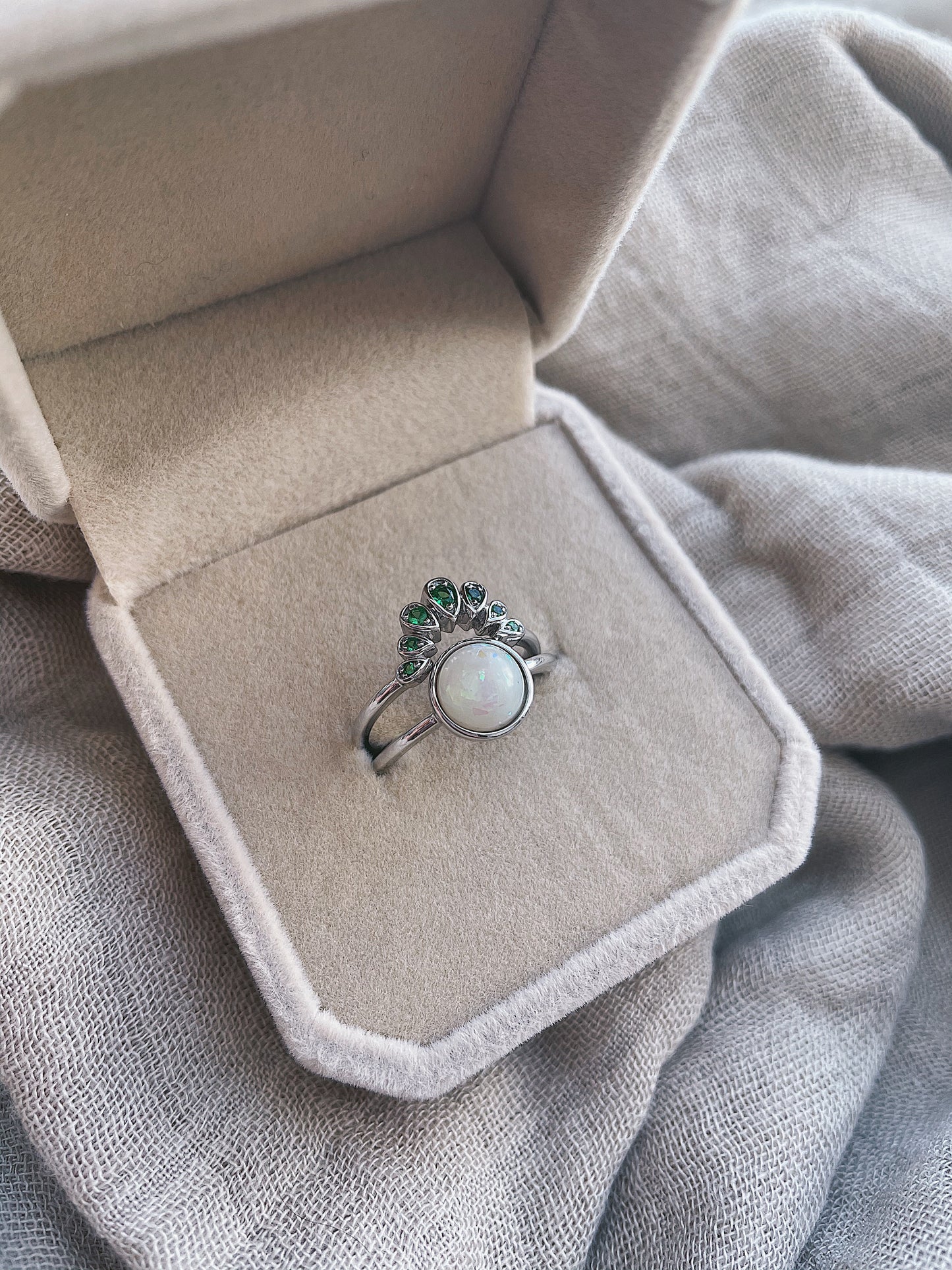 Detail of solid gold Cradle Rings with a preserved element stone and birthstone