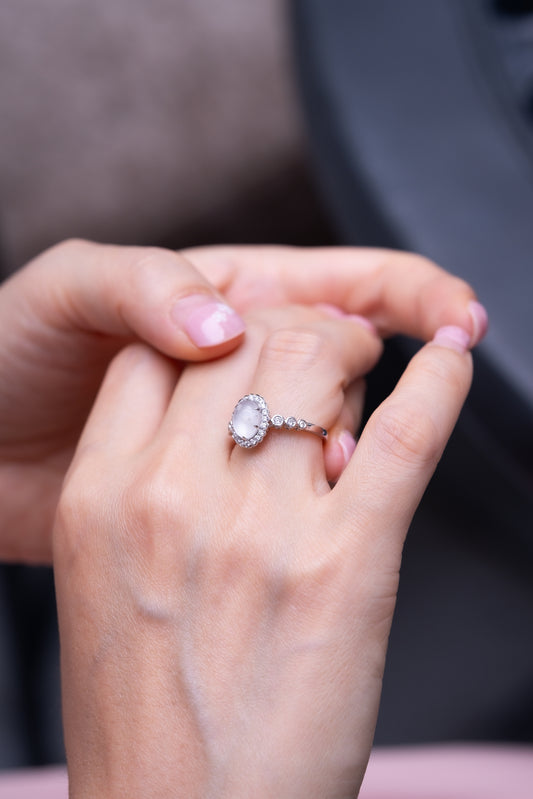 Eternity Ring, a breastmilk stone framed by a diamond halo with diamonds along the band