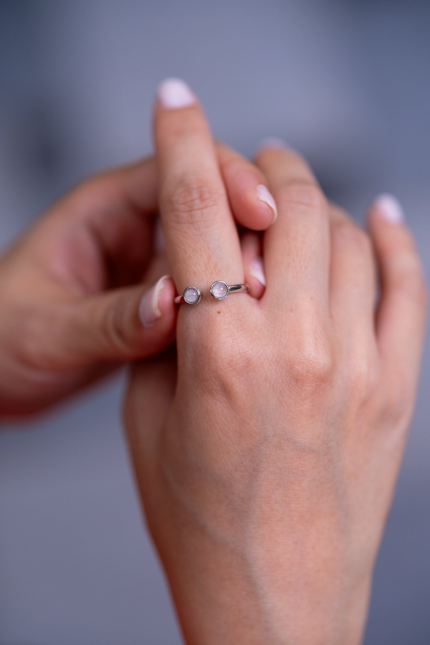 Solid gold breastmilk ring, the Embrace with two preserved stones facing one another