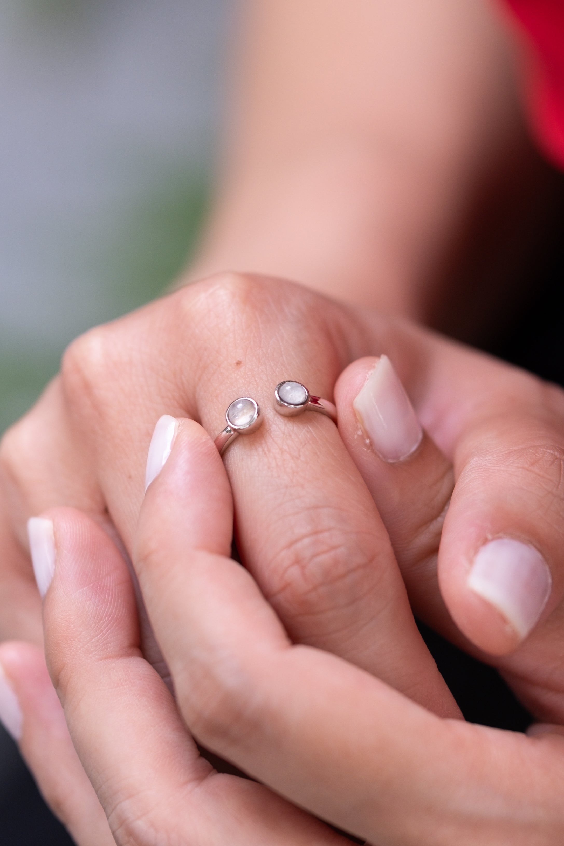 The Embrace Ring with two breastmilk stones on a delicate open band, in solid gold
