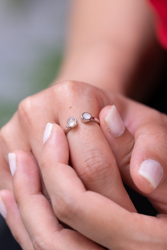 The Embrace Ring with two breastmilk stones on a delicate open band, in solid gold