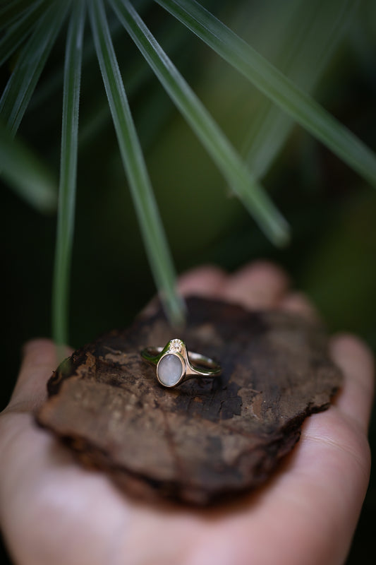 The North Star Ring with a breastmilk stone and diamond in a star-inspired setting, solid gold